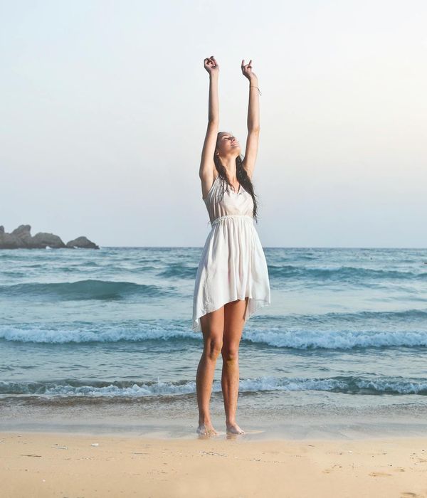 Woman feeling energized and stretching in the morning sun.
